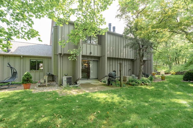 3745 Cedaridge Rd, Kalamazoo, MI 49008 - back of property with board and batten siding, a yard, and roof with shingles