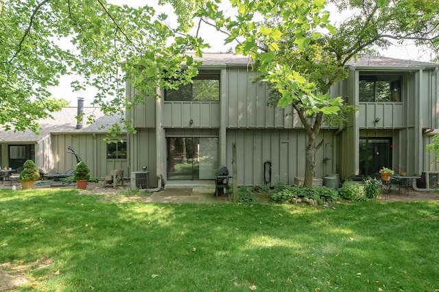 3745 Cedaridge Rd, Kalamazoo, MI 49008 - rear view of property with board and batten siding, roof with shingles, and a lawn