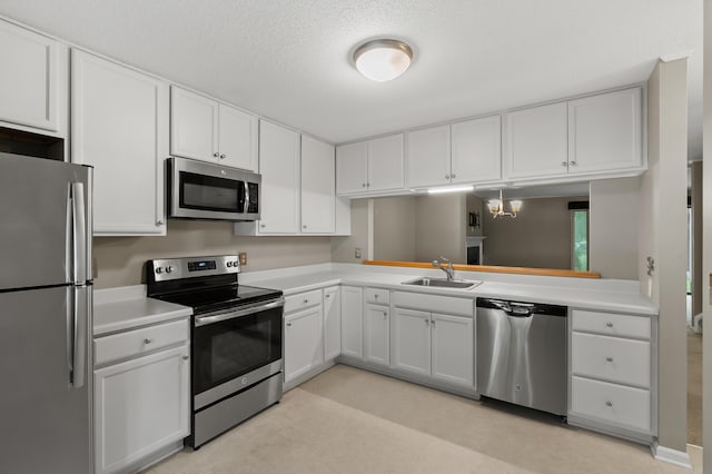 3745 Cedaridge Rd, Kalamazoo, MI 49008 - kitchen with stainless steel appliances, light countertops, white cabinetry, and a textured ceiling
