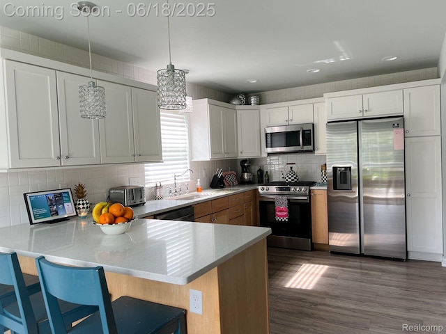 11236 Chyna Run, Davisburg, MI 48350 - kitchen with stainless steel appliances, a peninsula, decorative backsplash, decorative light fixtures, and dark wood-style floors