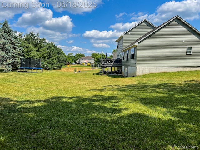 11236 Chyna Run, Davisburg, MI 48350 - view of grassy yard with a trampoline and a deck