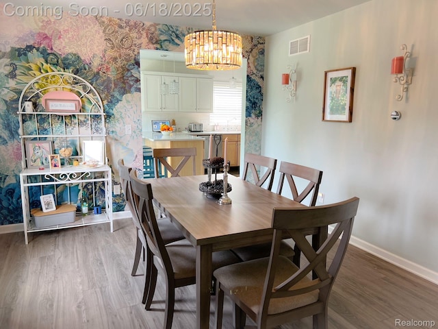 11236 Chyna Run, Davisburg, MI 48350 - dining space with light wood-type flooring, wallpapered walls, and a chandelier