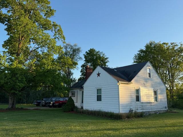 6185 Wing Ave SE, Grand Rapids, MI 49512 - view of property exterior featuring a chimney and a lawn