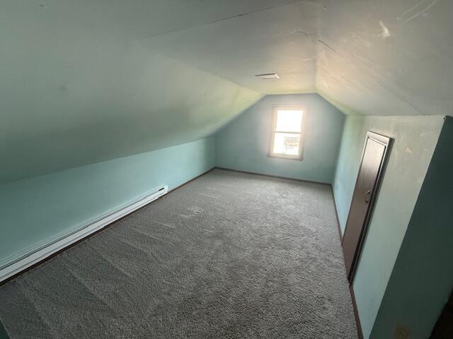 6185 Wing Ave SE, Grand Rapids, MI 49512 - additional living space with vaulted ceiling, baseboard heating, and carpet floors