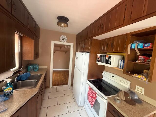 6185 Wing Ave SE, Grand Rapids, MI 49512 - kitchen featuring white appliances, light countertops, light tile patterned flooring, and brown cabinets