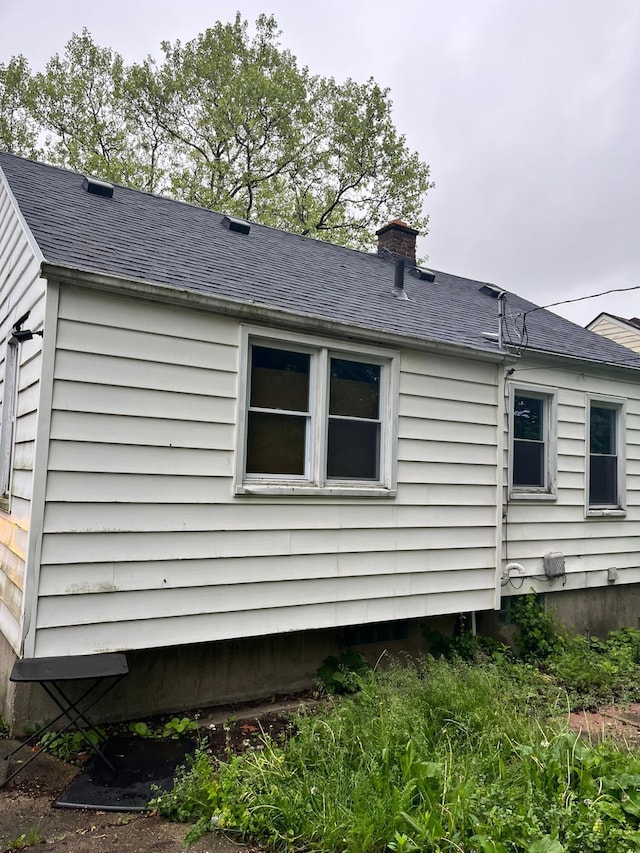 8627 Stout St, Detroit, MI 48228 - view of property exterior featuring roof with shingles and a chimney
