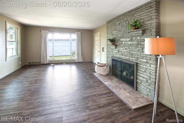 1861 Ladd Rd, Wolverine Lake, MI 48390 - unfurnished living room featuring a stone fireplace, wood finished floors, and a water view