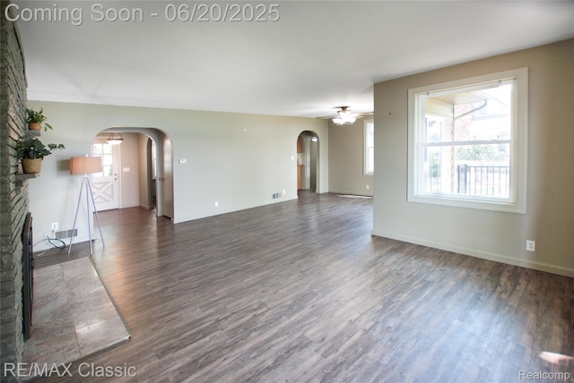 1861 Ladd Rd, Wolverine Lake, MI 48390 - unfurnished living room featuring arched walkways, wood finished floors, healthy amount of natural light, and a ceiling fan