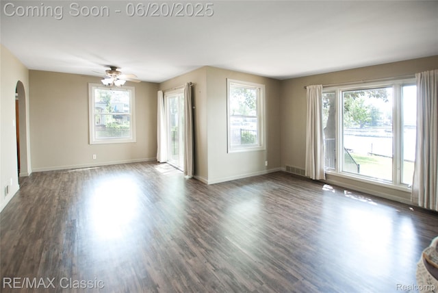 1861 Ladd Rd, Wolverine Lake, MI 48390 - spare room with arched walkways, dark wood finished floors, and a ceiling fan