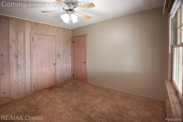 1861 Ladd Rd, Wolverine Lake, MI 48390 - unfurnished bedroom with carpet flooring, wood walls, and a closet