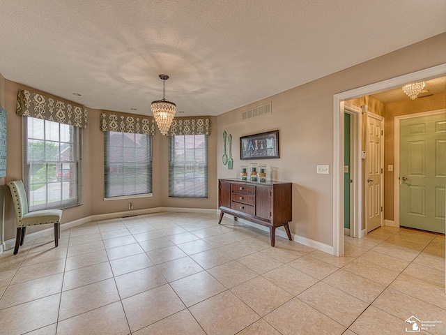831 Saint James Park Ave, Monroe, MI 48161 - unfurnished dining area featuring a chandelier, light tile patterned flooring, and a textured ceiling