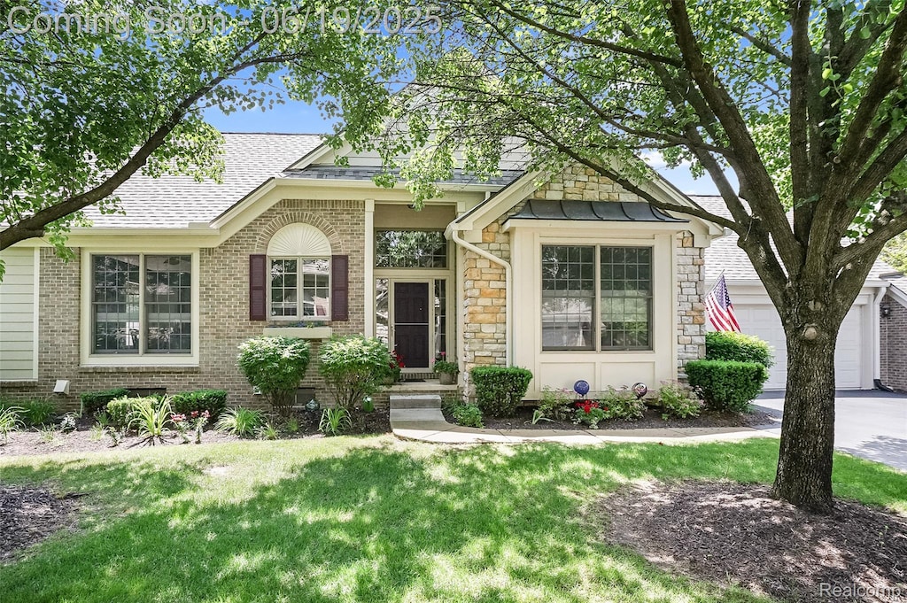 16822 Lochmoor Cir W, Northville, MI 48168 - view of front of property with a shingled roof, a front yard, brick siding, stone siding, and concrete driveway