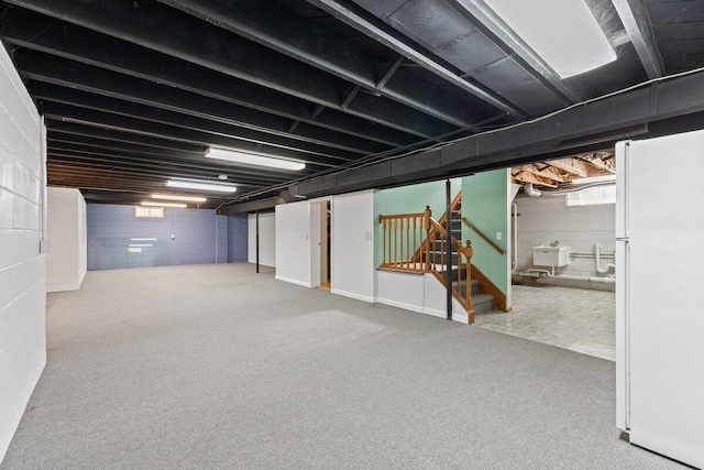 1228 Orchid St, Waterford, MI 48328 - below grade area with freestanding refrigerator, stairway, carpet, and plenty of natural light