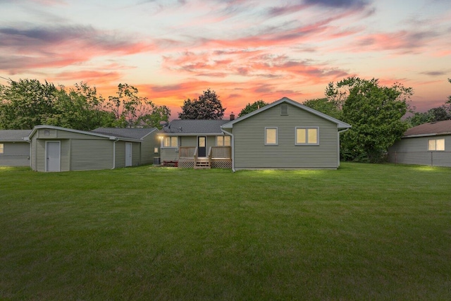 1228 Orchid St, Waterford, MI 48328 - back of property at dusk with a wooden deck, a yard, and an outbuilding