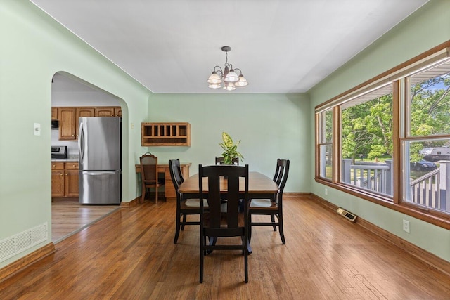 1228 Orchid St, Waterford, MI 48328 - dining area featuring a chandelier, hardwood / wood-style flooring, and arched walkways
