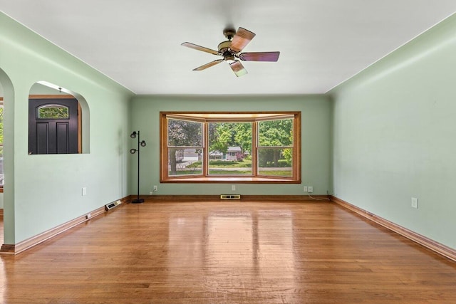 1228 Orchid St, Waterford, MI 48328 - empty room featuring wood finished floors, arched walkways, and ceiling fan