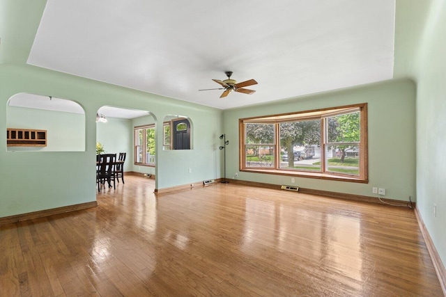 1228 Orchid St, Waterford, MI 48328 - unfurnished living room with ceiling fan, wood finished floors, and arched walkways