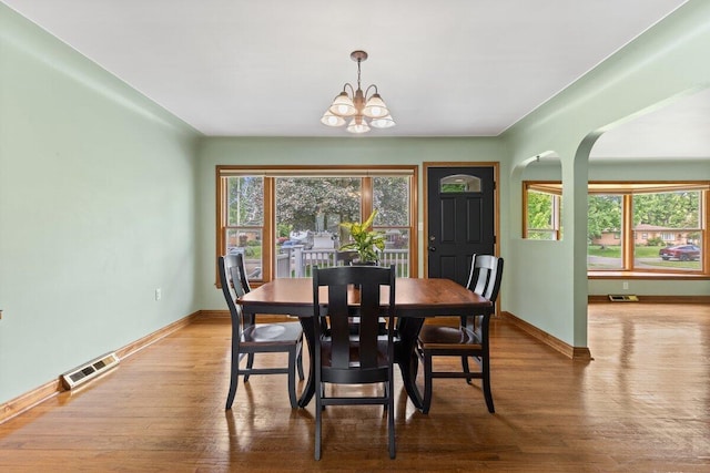 1228 Orchid St, Waterford, MI 48328 - dining room with arched walkways, a chandelier, and wood finished floors
