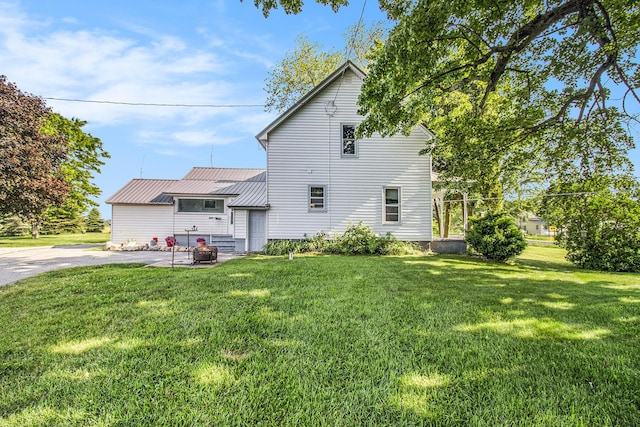 3833 S Baldwin Ave, Fremont, MI 49412 - back of property with a yard, a metal roof, and a patio