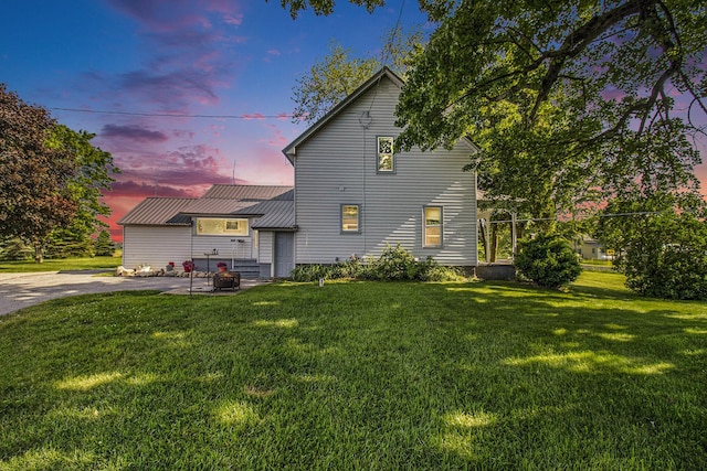 3833 S Baldwin Ave, Fremont, MI 49412 - back of property at dusk featuring a lawn and a metal roof