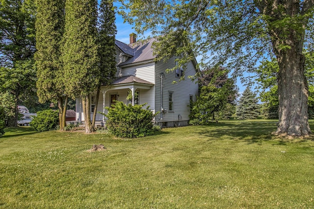 3833 S Baldwin Ave, Fremont, MI 49412 - view of property exterior featuring a porch, a chimney, a lawn, and a metal roof