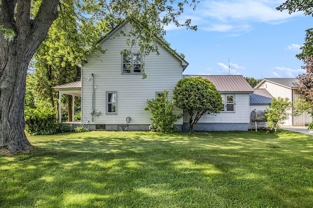 3833 S Baldwin Ave, Fremont, MI 49412 - back of house featuring a metal roof and a lawn