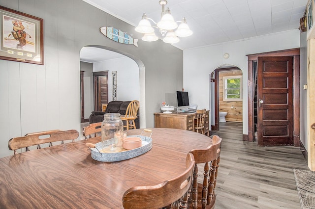 3833 S Baldwin Ave, Fremont, MI 49412 - dining area with arched walkways, a chandelier, ornamental molding, and wood finished floors
