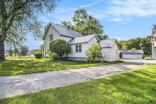 3833 S Baldwin Ave, Fremont, MI 49412 - view of side of home featuring a lawn, a metal roof, and a chimney