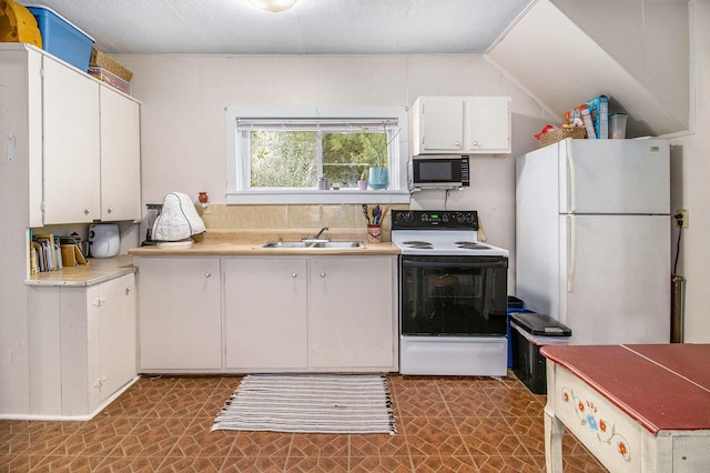 630 State St, Fremont, MI 49412 - kitchen featuring range with electric cooktop, stainless steel microwave, freestanding refrigerator, white cabinetry, and light countertops