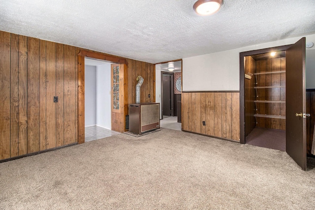 630 State St, Fremont, MI 49412 - carpeted empty room with wooden walls and a textured ceiling
