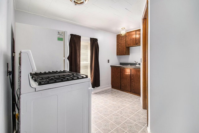 630 State St, Fremont, MI 49412 - kitchen featuring white range with gas cooktop and light tile patterned floors
