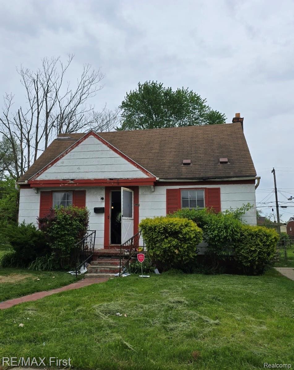 537 Campbell St, River Rouge, MI 48218 - view of front of home featuring a front yard, a chimney, entry steps, and roof with shingles