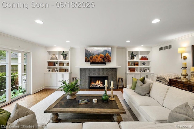586 Fairfax St, Birmingham, MI 48009 - living room with ornamental molding, wood finished floors, recessed lighting, a tiled fireplace, and built in shelves