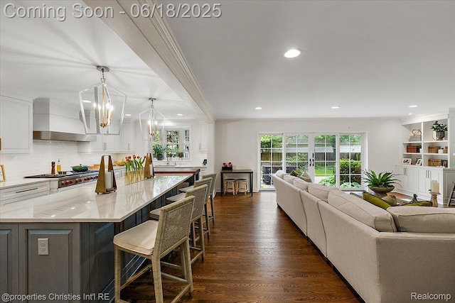 586 Fairfax St, Birmingham, MI 48009 - kitchen with ornamental molding, wall chimney exhaust hood, white cabinetry, open floor plan, and recessed lighting