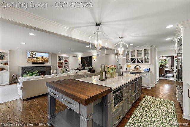 586 Fairfax St, Birmingham, MI 48009 - kitchen featuring butcher block countertops, white cabinets, dark wood-style floors, glass insert cabinets, and ornamental molding