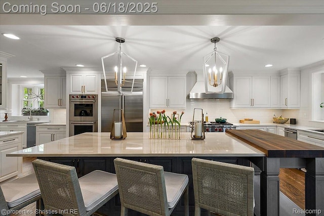 586 Fairfax St, Birmingham, MI 48009 - kitchen with appliances with stainless steel finishes, a chandelier, white cabinets, recessed lighting, and a kitchen breakfast bar