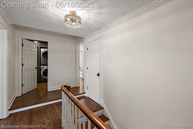 586 Fairfax St, Birmingham, MI 48009 - hallway featuring stacked washer / dryer, dark wood-style floors, crown molding, and a chandelier