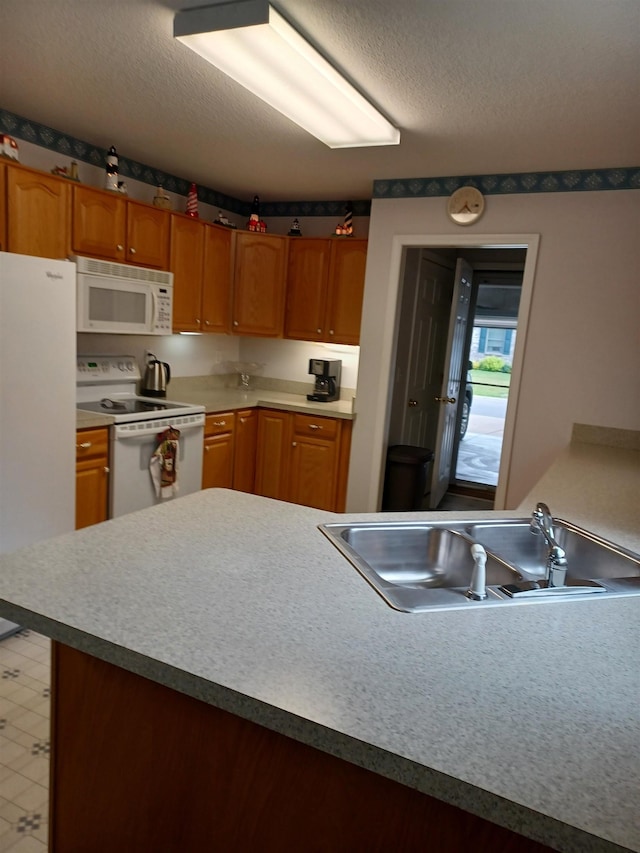 3144 Amsterdam Dr, Clio, MI 48420 - kitchen featuring white appliances, a textured ceiling, brown cabinetry, and light floors