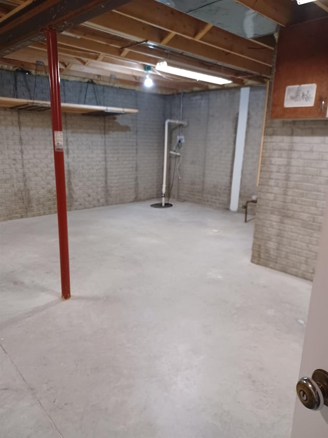 3144 Amsterdam Dr, Clio, MI 48420 - unfinished below grade area featuring brick wall and drainage system