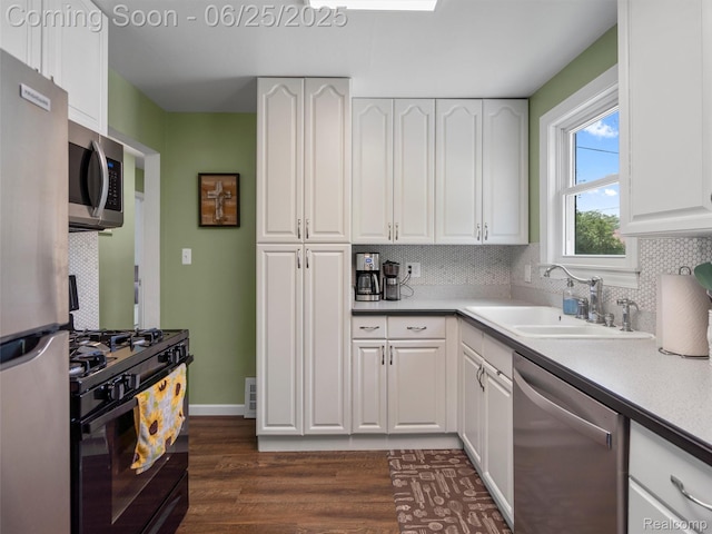 34286 Glover St, Wayne, MI 48184 - kitchen featuring stainless steel appliances, dark wood finished floors, backsplash, and white cabinets