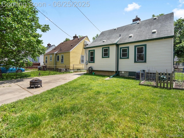 34286 Glover St, Wayne, MI 48184 - rear view of house with an outdoor fire pit, a chimney, a shingled roof, and a patio area