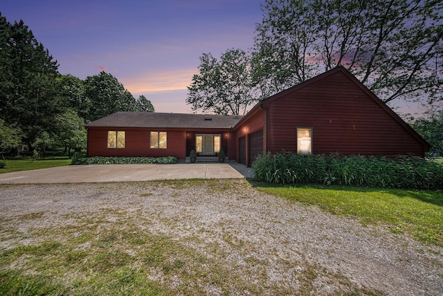 7385 Macomber Ct, Ann Arbor, MI 48103 - view of front of home with gravel driveway, an attached garage, and a yard