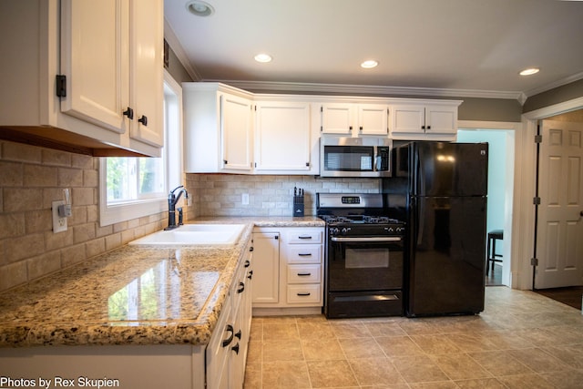 4767 S River St, Newaygo, MI 49337 - kitchen with stainless steel microwave, gas range oven, freestanding refrigerator, white cabinetry, and ornamental molding