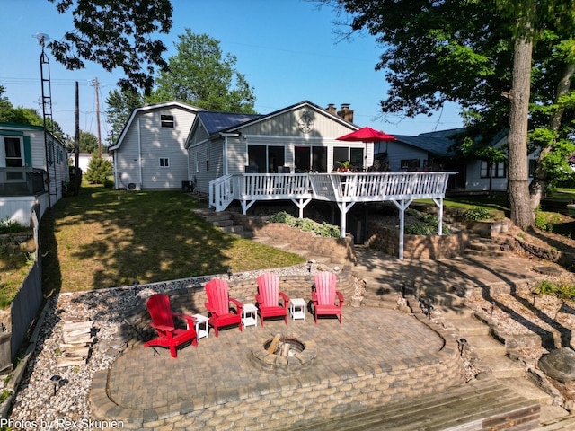 4767 S River St, Newaygo, MI 49337 - back of house with an outdoor fire pit, a patio area, a deck, a lawn, and a chimney