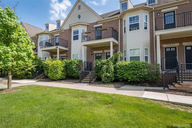25556 Portico Ln, Novi, MI 48375 - townhome / multi-family property featuring brick siding, a front yard, and a balcony