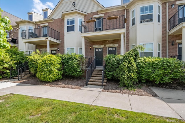 25556 Portico Ln, Novi, MI 48375 - townhome / multi-family property with brick siding and a balcony