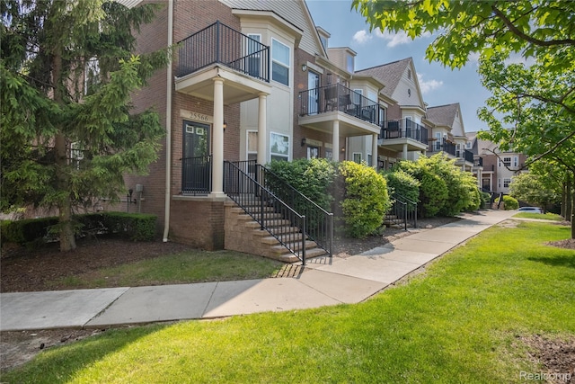 25556 Portico Ln, Novi, MI 48375 - entrance to property featuring brick siding, a yard, a balcony, and a residential view