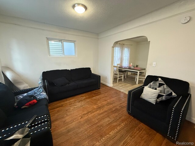 9208 Ward St, Detroit, MI 48228 - living area with arched walkways, wood finished floors, and a textured ceiling