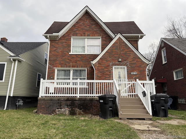 9208 Ward St, Detroit, MI 48228 - view of front of house with brick siding, a wooden deck, and a front yard