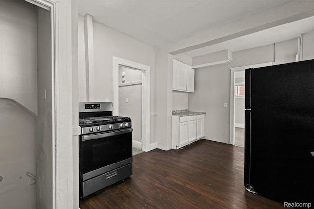 4334 Pacific St, Detroit, MI 48204 - kitchen with stainless steel gas stove, freestanding refrigerator, dark wood-type flooring, white cabinetry, and light stone countertops